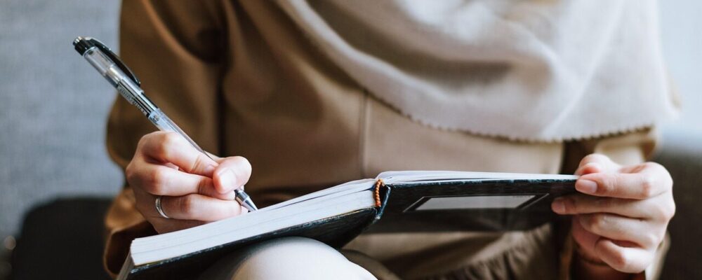 Frau schreibt ihre Finanzen in ein Buch