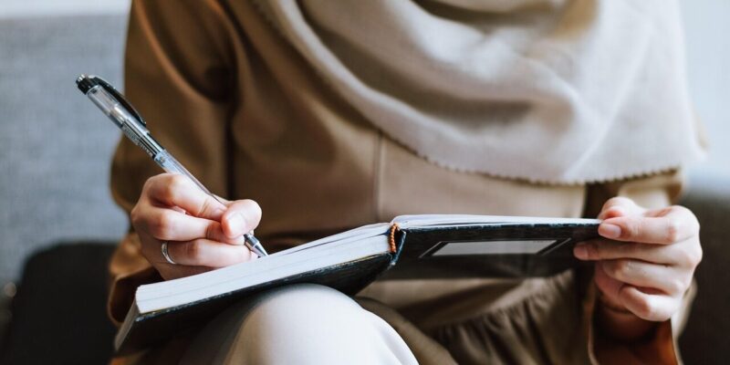 Frau und Finanzen Frau schreibt ihre Finanzen in ein Buch