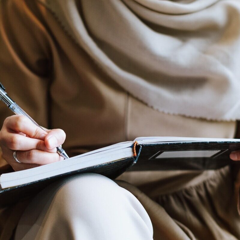 Frau schreibt ihre Finanzen in ein Buch
