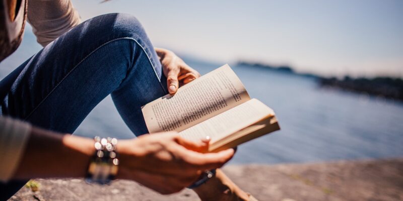 Frau entspannt am Meer Frau liest ein Buch am Meer