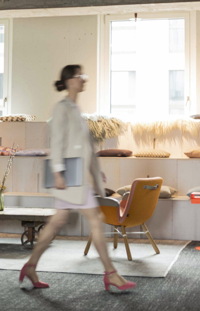 Alles-ist-möglich-geht-an-der-Realität-vorbei Janine Frank läuft durch ein helles Büro mit einem Laptop in der Hand. Durch die Bewegung sieht man sie nur verschwommen.