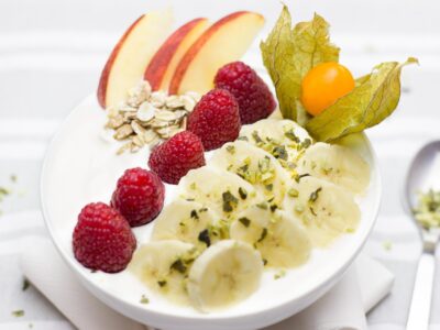 Beeren, Joghurt und Nüsse auf einem weissen Teller angerichtet