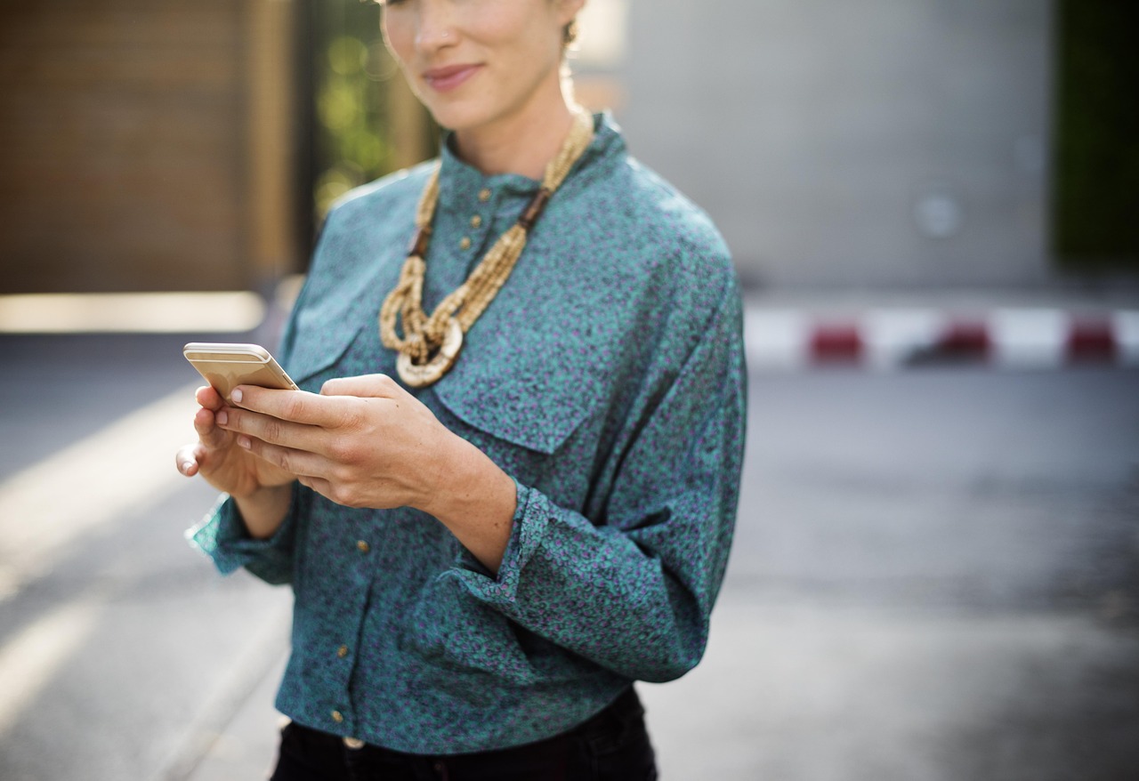 Zu den News Frau mit Handy in der Hand die ihr Online Business aufbaut