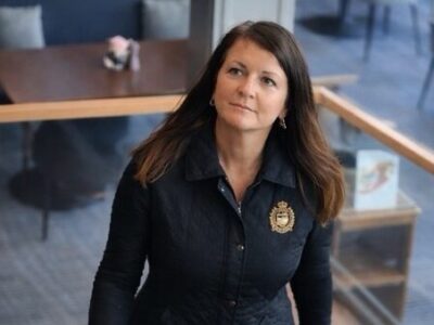 Dr. Anja Ozik-Scharf läuft die Treppe hoch und schaut freundlich zur Seite.