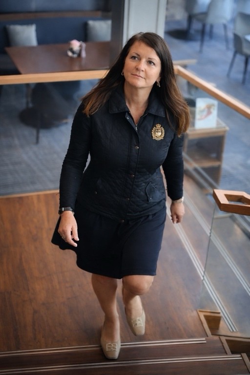 Dr. Anja Ozik-Scharf läuft die Treppe hoch und schaut freundlich in die Kamera