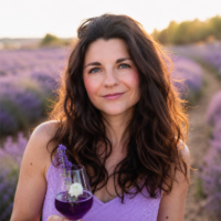 Veronika Ebert hält ein Glas lavabelle in der Hand vor einem Lavendelfeld